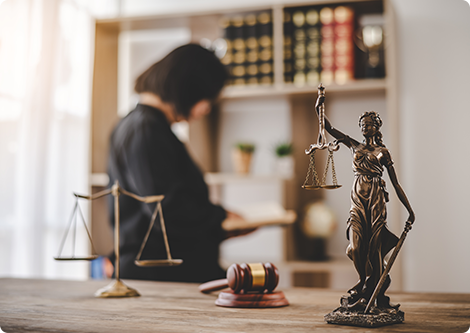 Lady Justice statue and gavel with a lawyer reading; promoting ILAs over virtual paralegals.