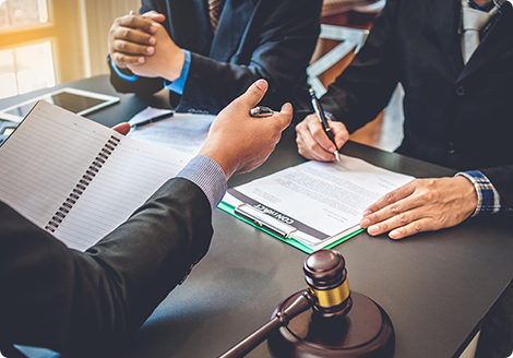 Group of people discussing documents around a table with a gavel, illustrating legal workflow efficiency.  
