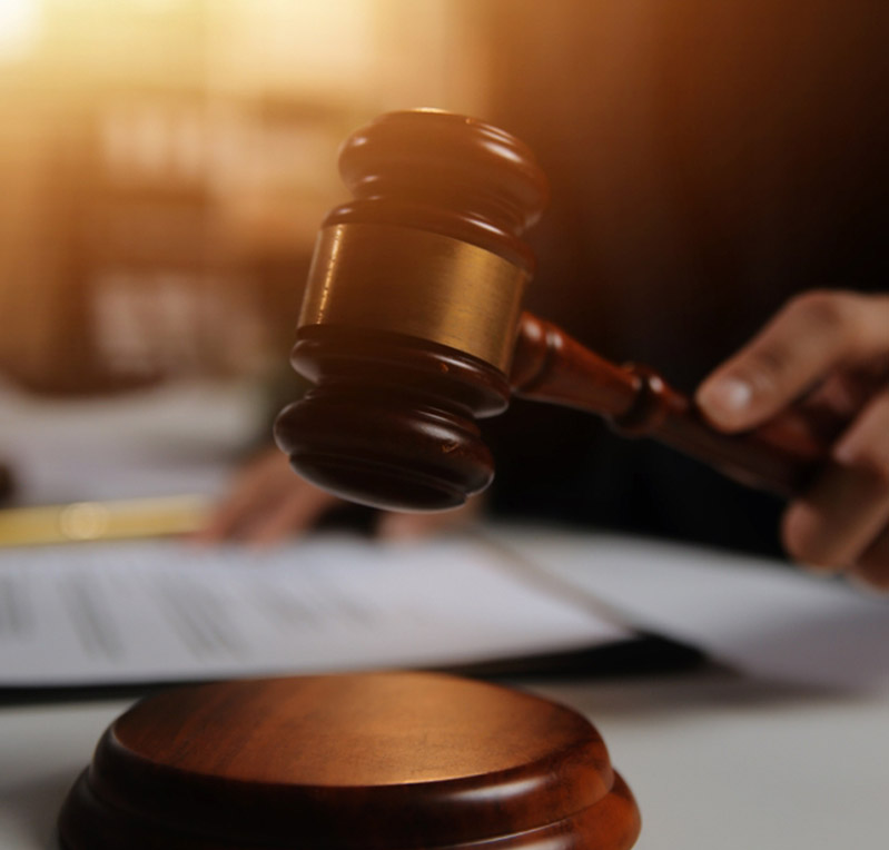 Gavel over paperwork with warm sunlight in the background.