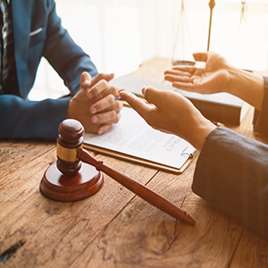 Lawyer consulting with client next to a legal gavel; legal representation and advocacy.