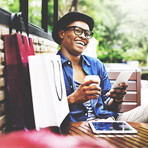 Happy person relaxing outdoors with coffee and digital tablet on weekend