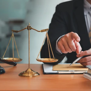 Attorney reviewing documents at a desk with scales of justice